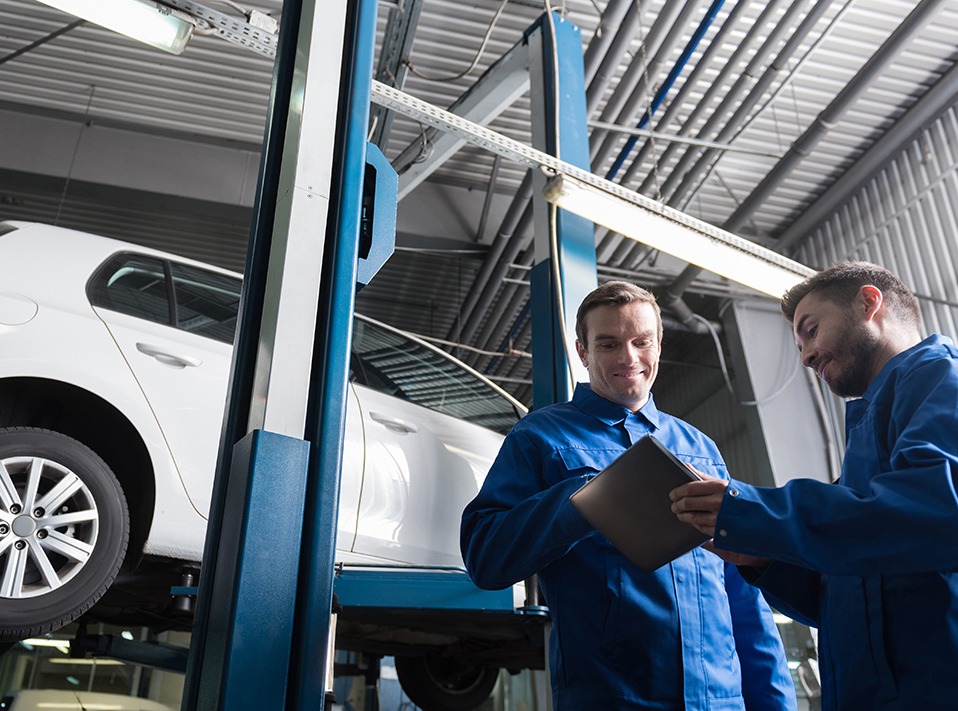 two mechanics checking over a vehicle on a service ramp - MOT & Servicing London Borough of Hackney